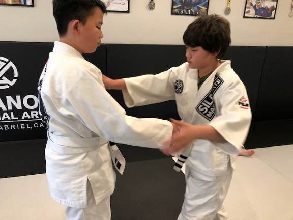 Jaelan working his Jiu-Jitsu takedown game with his training partner in the Kids 2 program at Silanoe.