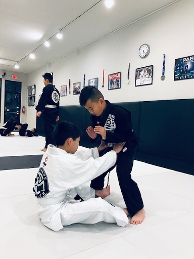 Caleb practising the Dummy Sweep in the BJJ Kids Class with Devon