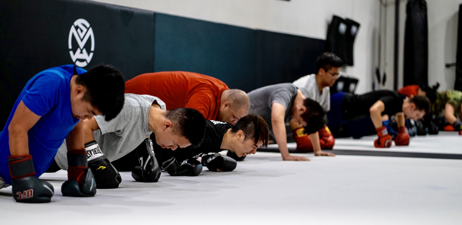 Joe Hernandez in pushup stance with Kickboxing Muay Thai teammates at Silanoe San Gabriel Alhambra adjacent