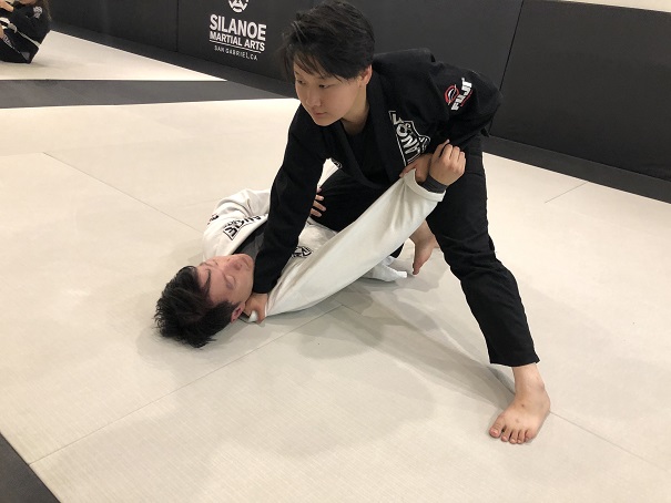 Fonda Lo demonstrating the Knee on Belly technique on her partner in the BJJ Al Levels