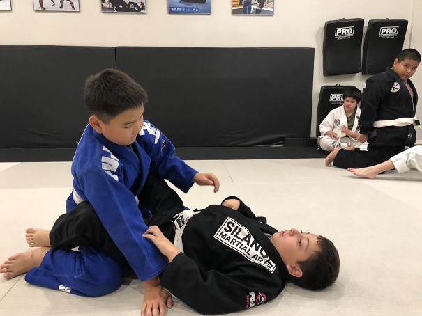 Kyle in blue and Nicholas in black training together in the Jiu-Jitsu kids 2 program at Silanoe Martial Arts San Gabriel Alhambra adjacent. 