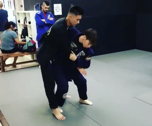Ivan Giang is practicing his BJJ Hip Toss Throw technique on Wah Wu on the back mat at the Silanoe dojo in San Gabriel. 