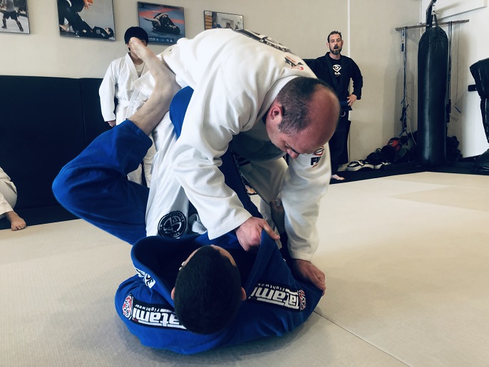Student of the Month Robert Terriquez(white gi) is training with teammate Tomas Morales(blue gi). He is trying to passing the SLX guard.