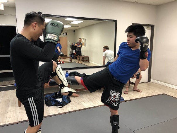 Alhambra High School student Caleb Luong executing a perfect leg kick on his training partner Johny Ta in the Muay Thai Kickboxing class at Silanoe Martial Arts in San Gabriel Alhambra.