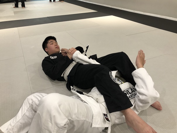 White Belt in BJJ Caleb Luong finish his match with an armbar submission at the Teens Fundamentals class at Silanoe Martial Arts.