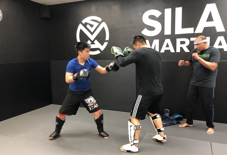 Student of the Month Sean Lee on the right coaching his training partners Caleb Luong on the left and Johny Ta on the right at a Monday Muay Thai Kickboxing class.