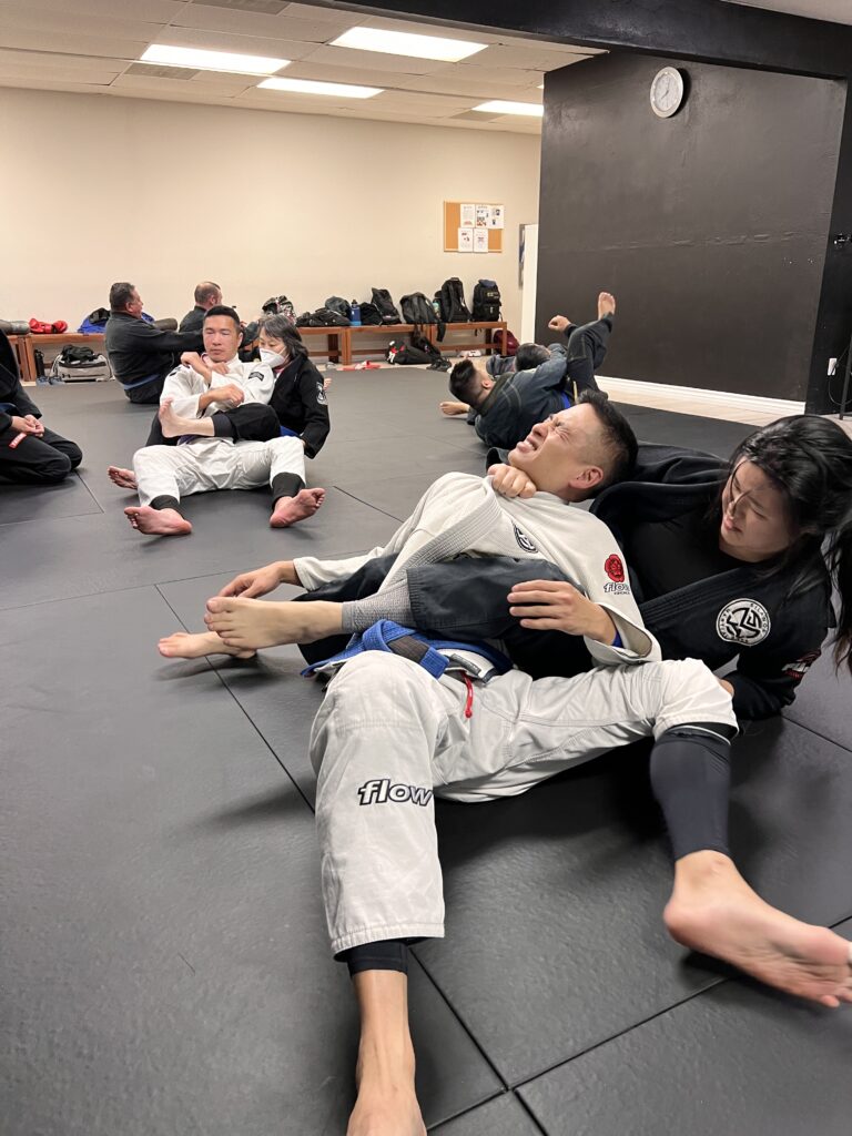 Angela applying a Bow and Arrow choke on Jimmy